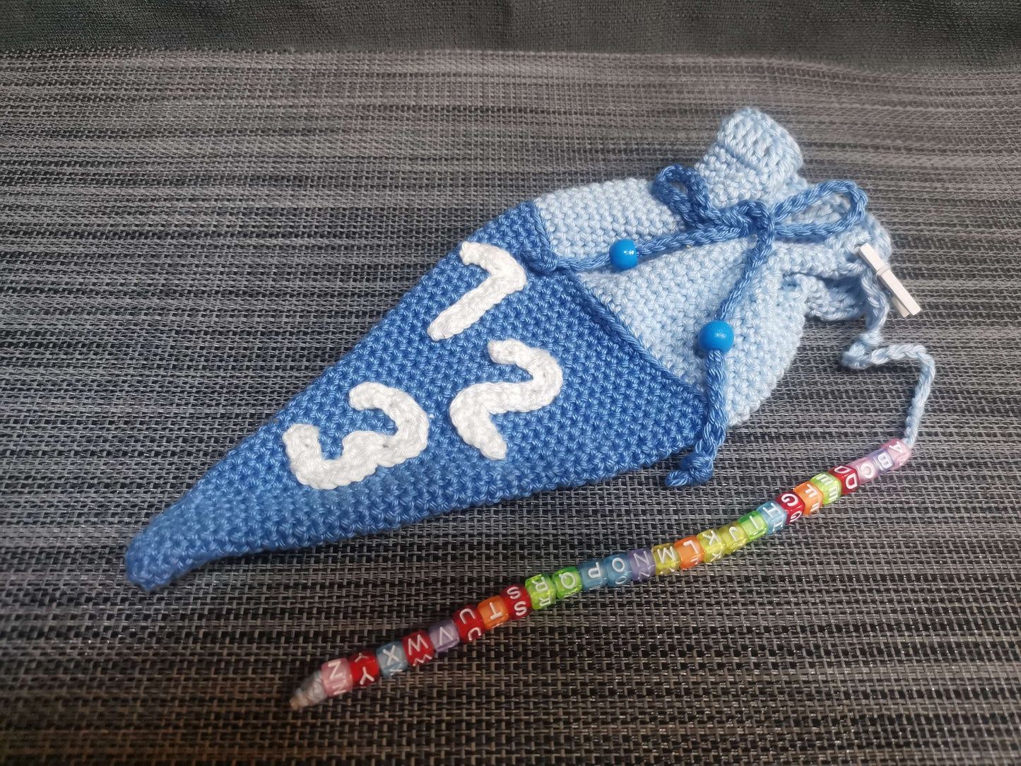 Handgehäkelte Mini-Schultüte in Blau mit ABC-Kette, 23 cm hoch, 10 cm breit – Einschulungsgeschenk von bw-handmade.