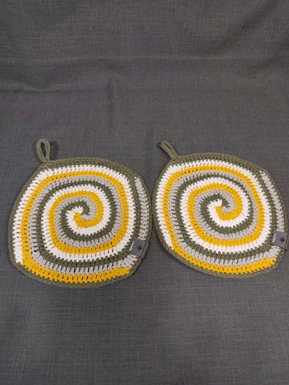 Zwei handgehäkelte Topflappen mit Spiralmuster in Weiß, Gelb, Grau und Grün