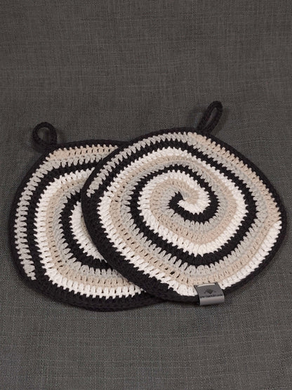 Zwei handgehäkelte Topflappen mit Spiralmuster in Weiß, Beige, Grau und Schwarz