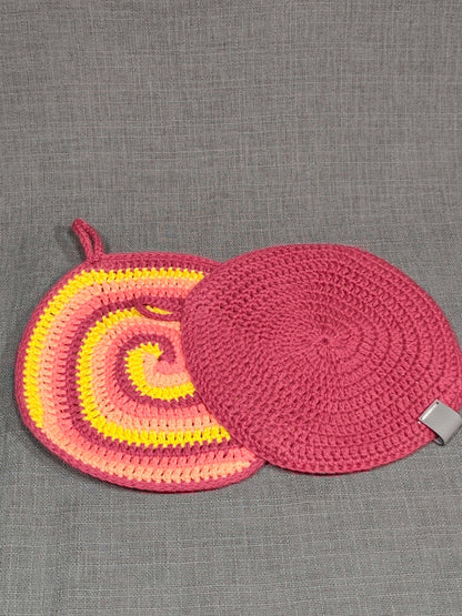 Gehäkelte Topflappen mit buntem Spiralmuster und einfarbig dunkelroter Rückseite