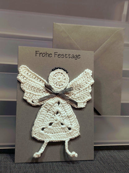 Handgefertigte Weihnachtskarte mit cremeweißem gehäkeltem Engel und grauer Schleife
